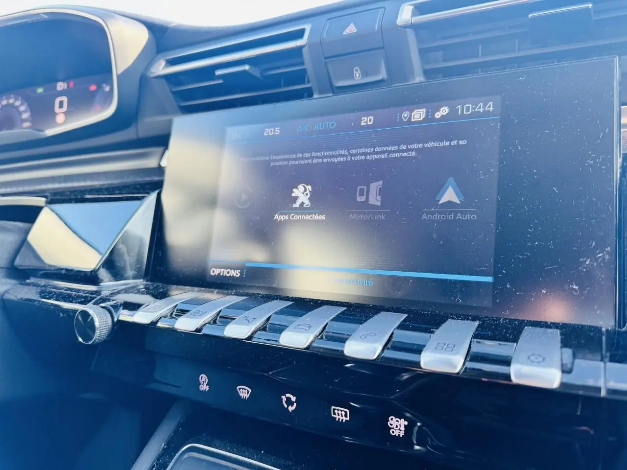 Vue rapprochée de la console centrale tactile et des commandes piano chromées du Peugeot 508 gris Amazonite, intérieur noir.