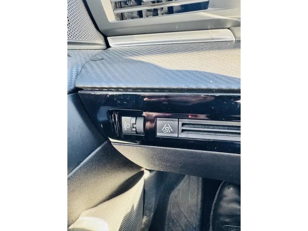 Gros plan sur la console côté conducteur de la Peugeot 508 gris amazonite, avec commandes d’éclairage et ventilation.