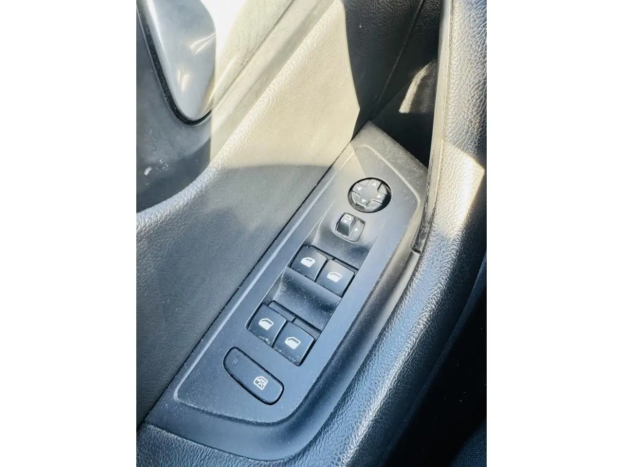 Gros plan sur les commandes des vitres électriques côté conducteur d'une Peugeot 508 gris amazonite, intérieur noir.