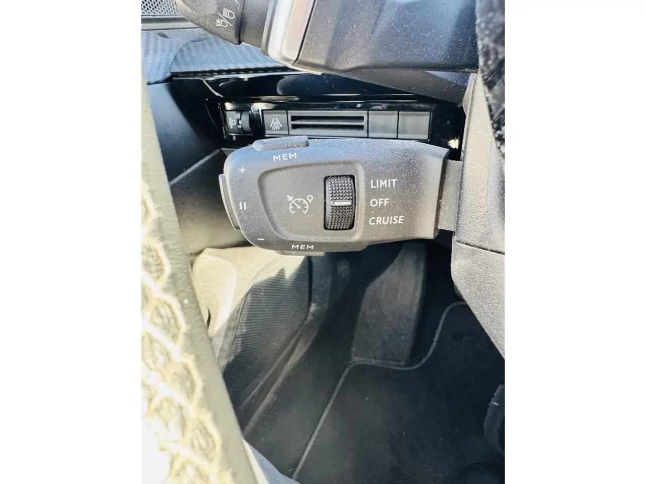 Gros plan sur la commande de régulateur de vitesse au volant d'une Peugeot 508 gris amazonite, intérieur noir.