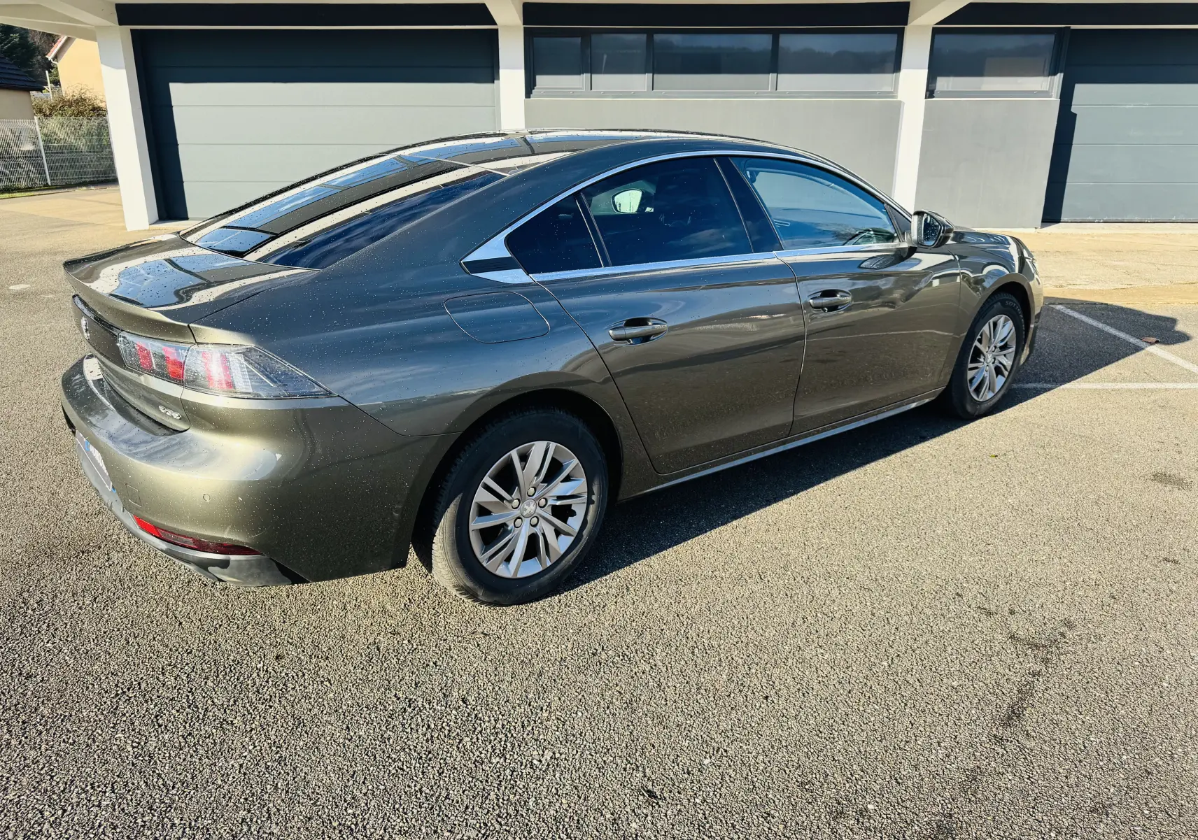 Peugeot 508 gris amazonite vue 3/4 arrière droit, avec jantes alliage et feux arrière LED distinctifs.