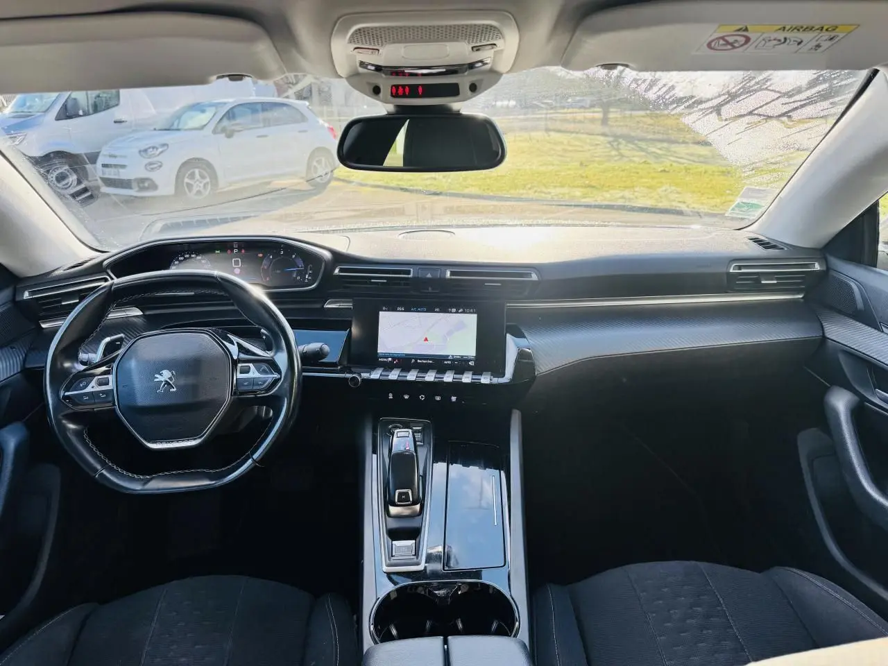 Vue intérieure avant du Peugeot 508 gris amazonite, avec tableau de bord numérique et écran tactile central.