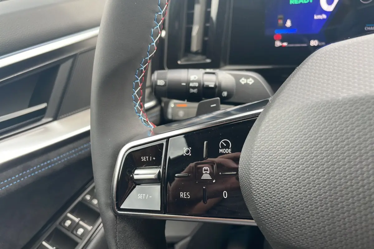 Gros plan sur le volant cuir multifonctions avec surpiqûres tricolores du Renault Austral New 200 Esprit Alpine.