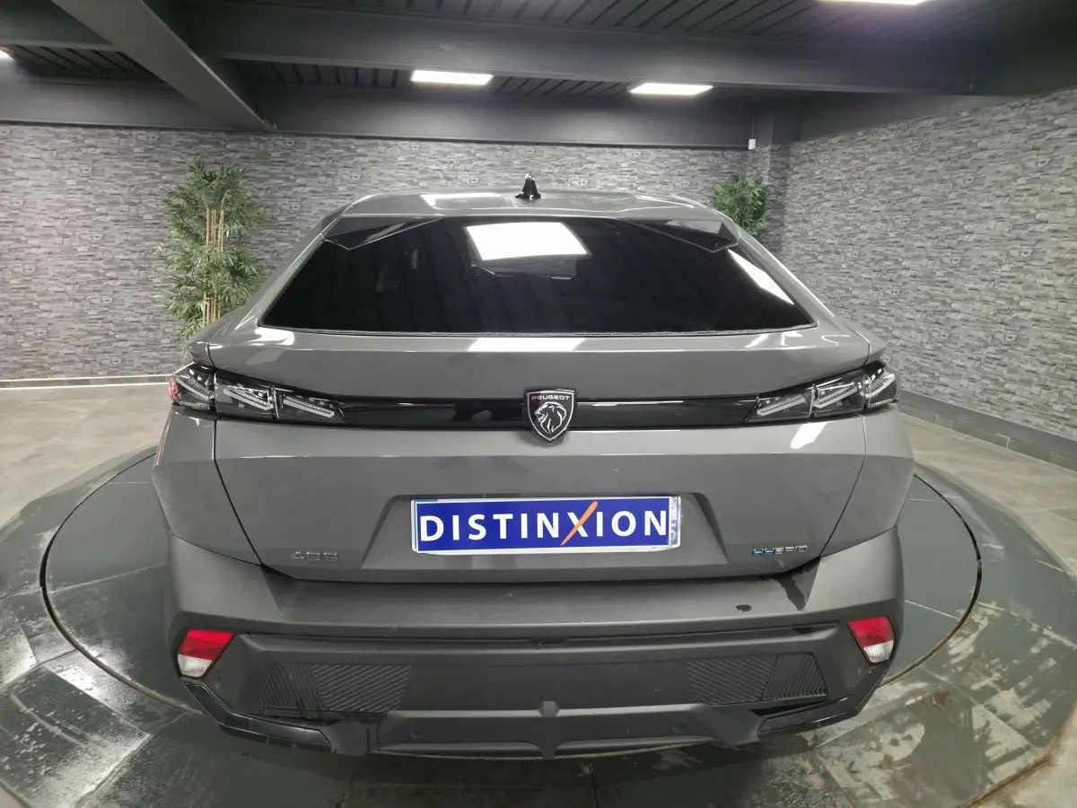 Vue arrière d'une Peugeot 408 gris métallisé avec logo lion noir et feux arrière à design anguleux.