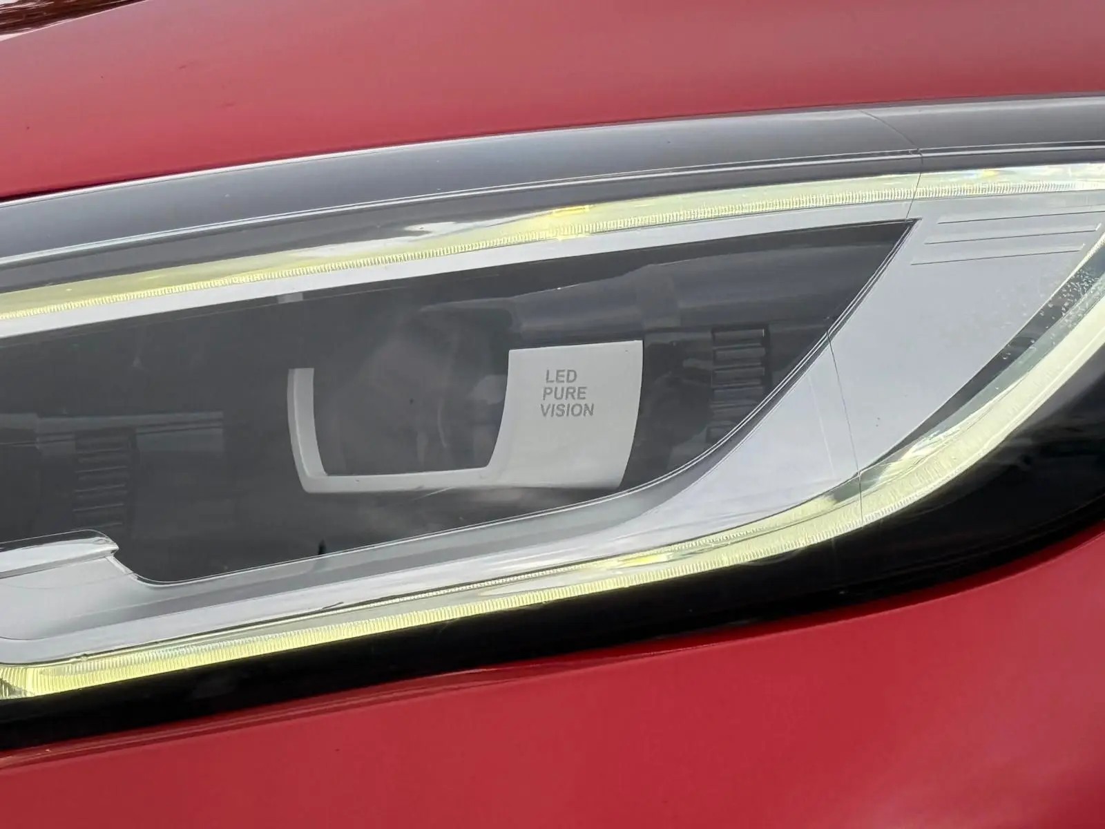 Gros plan sur le phare avant droit LED Pure Vision d’un Renault Kadjar rouge flamme de 2016.