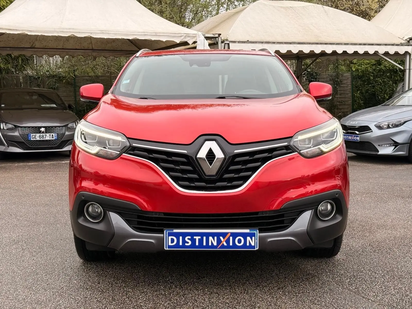 Vue frontale d'un Renault Kadjar rouge flamme avec calandre noire et logo chromé bien visible.