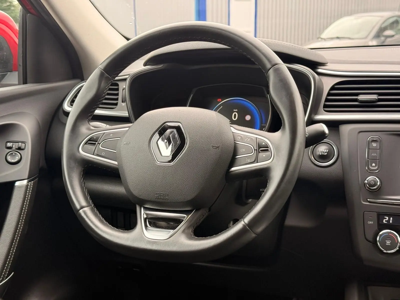 Vue rapprochée du volant en cuir noir d’un Renault Kadjar 2016, avec tableau de bord digital et bouton start/stop visible.