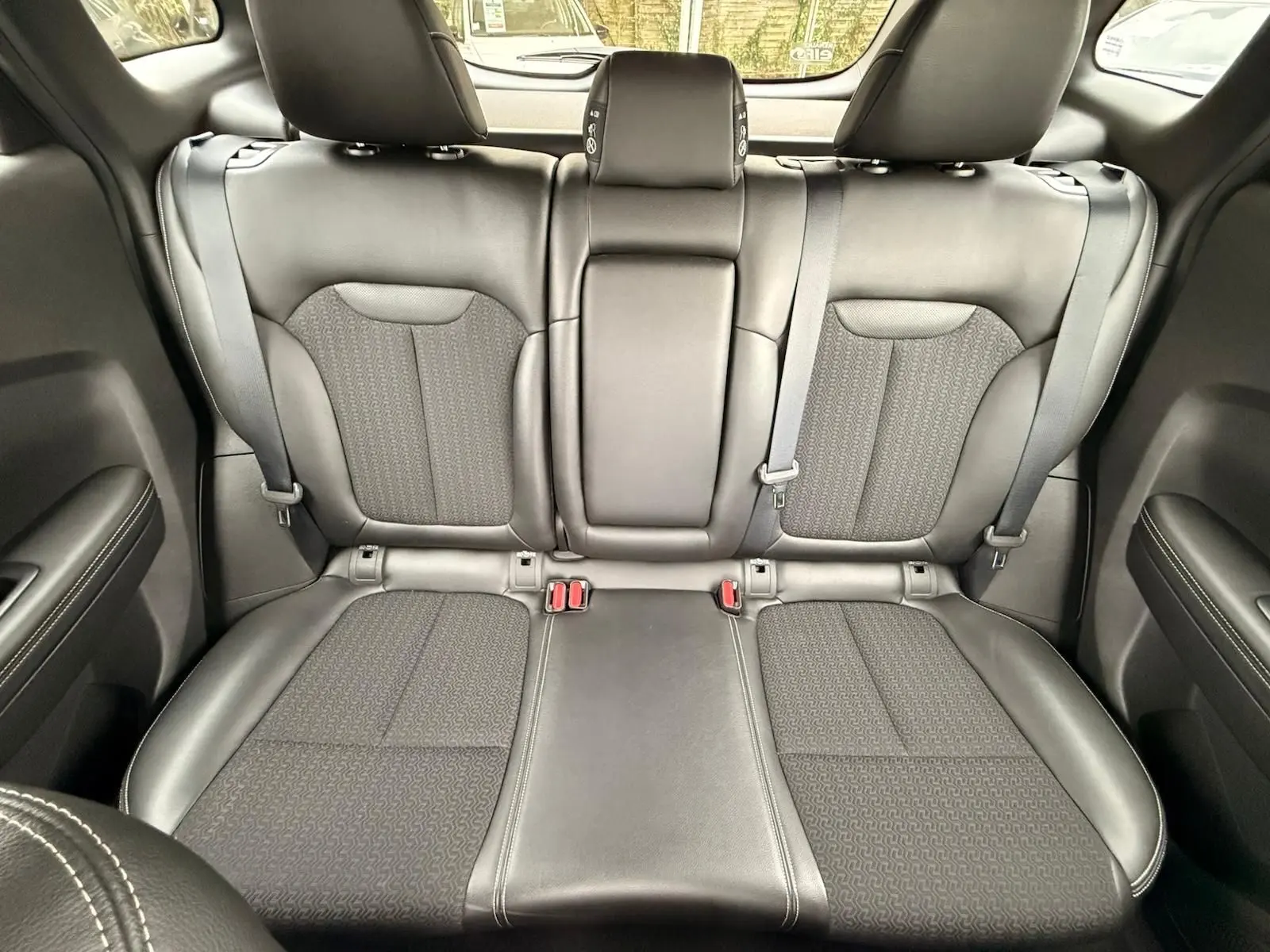 Vue intérieure montrant la banquette arrière en cuir noir du Renault Kadjar 1.2 TCE 130 Energy INTENS, sièges avec ceinture de sécurité.