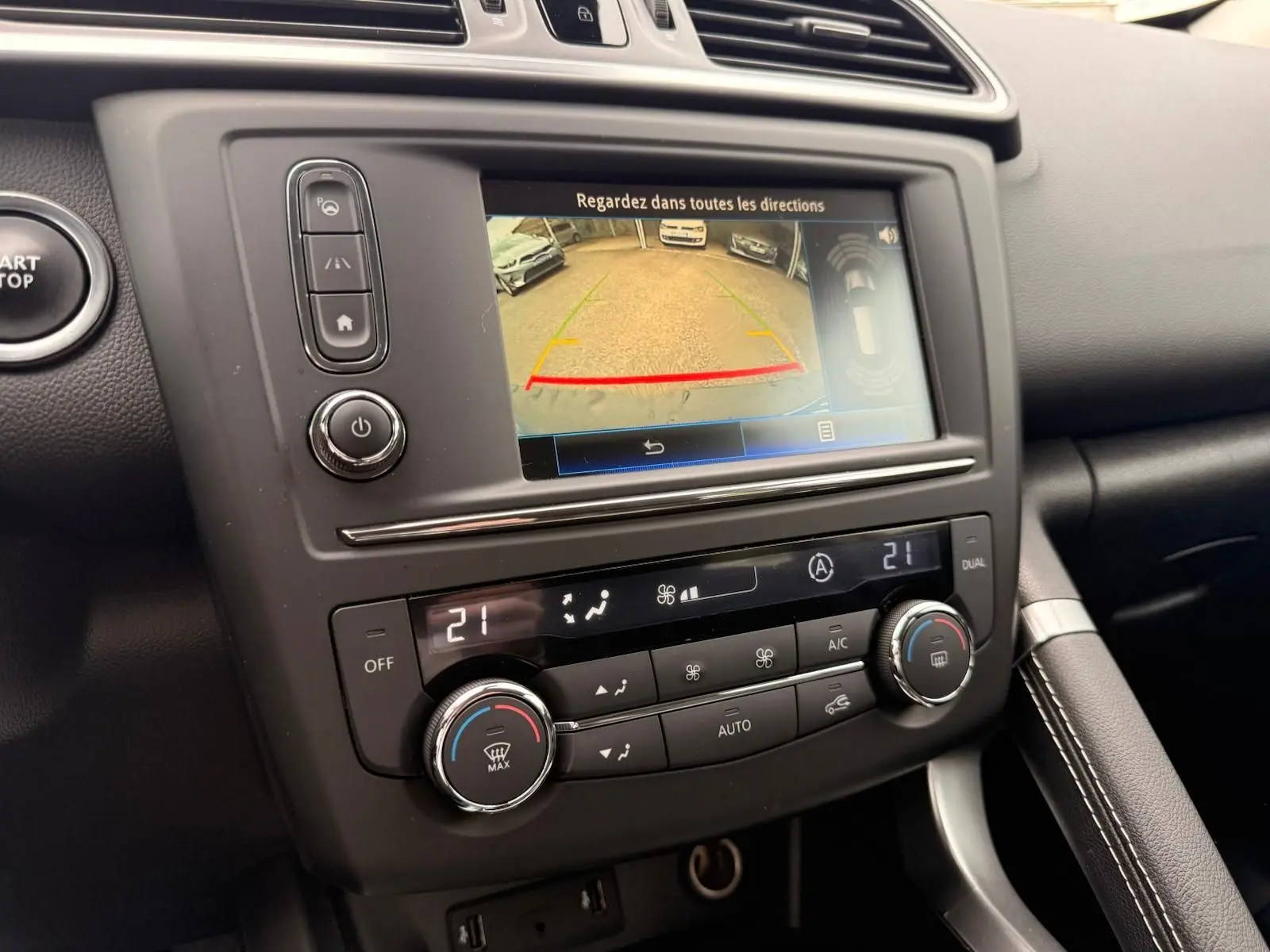 Vue rapprochée de la console centrale du Renault Kadjar 2016, écran de caméra de recul et commandes de climatisation visibles.