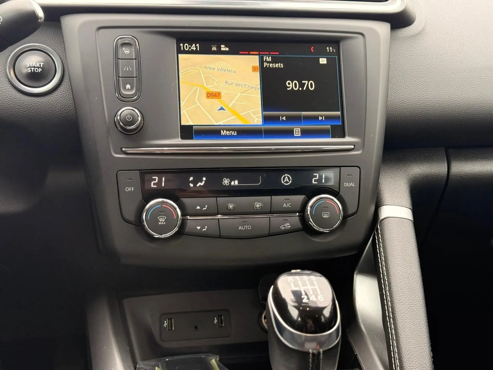 Vue rapprochée de la console centrale du Renault Kadjar 2016, avec écran tactile, climatisation et levier de vitesse manuel.