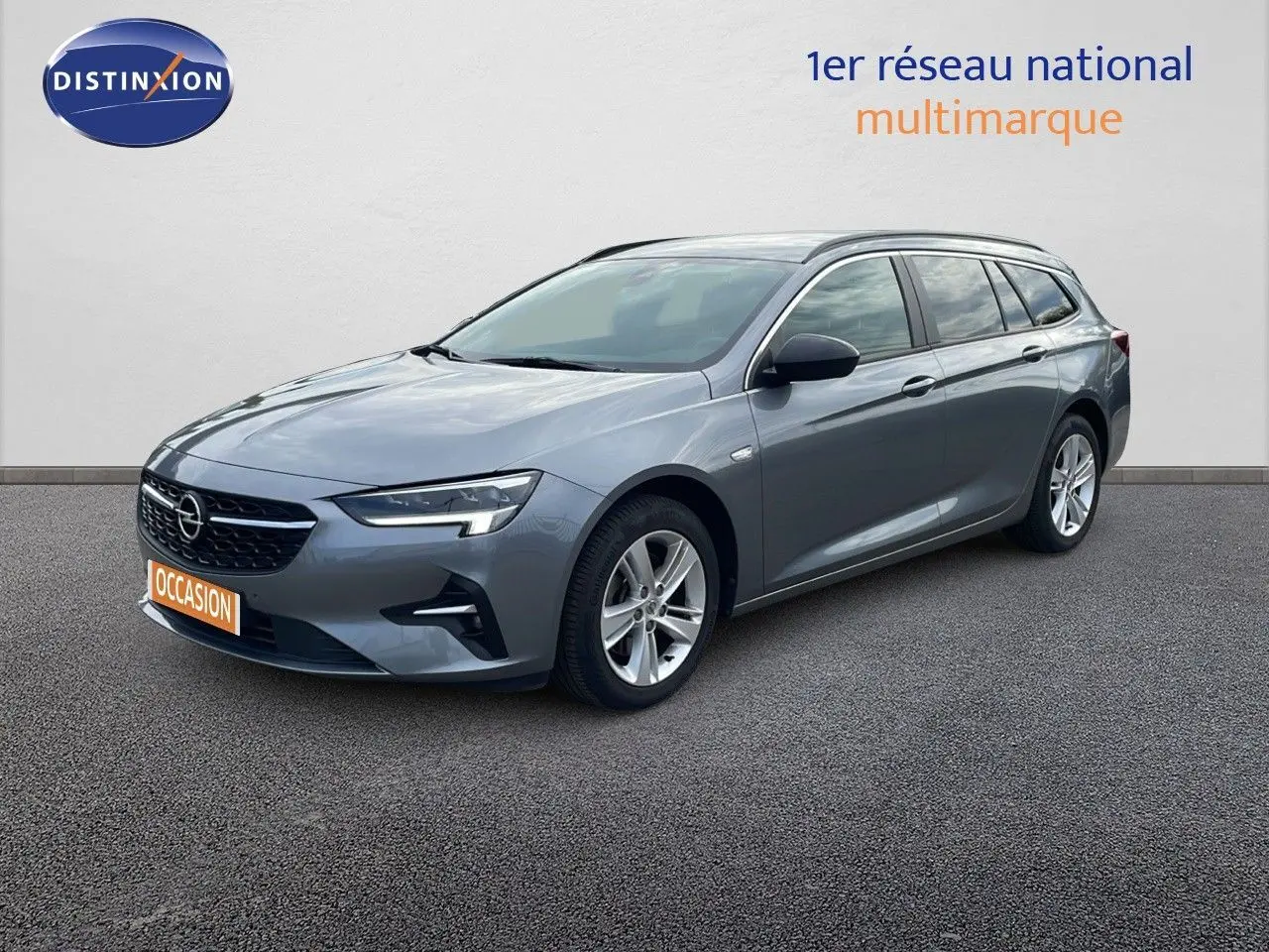 Opel Insignia Sports Tourer gris acier satiné vue 3/4 avant droit, avec jantes alliage et calandre noire.