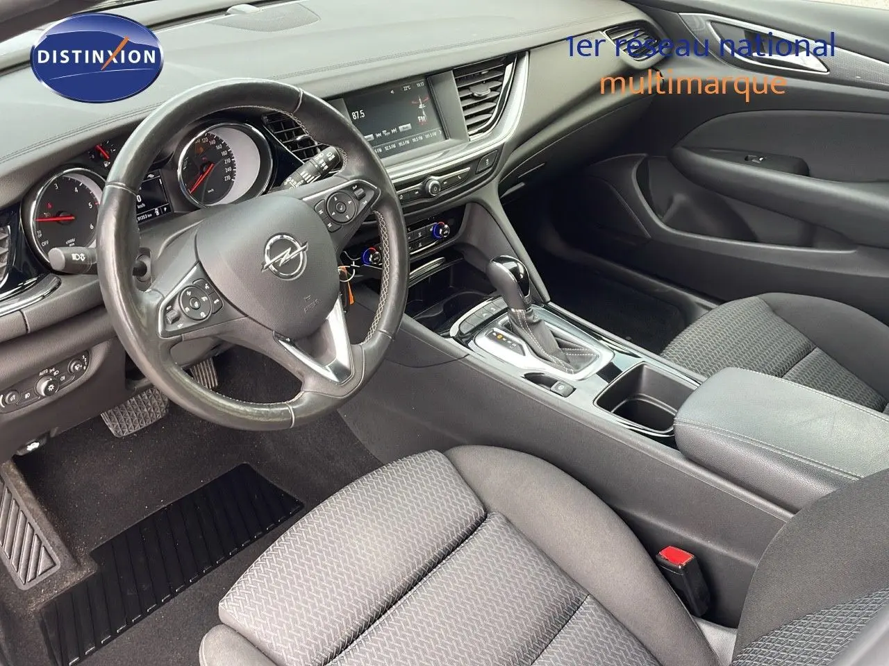 Vue intérieure côté conducteur de l’Opel Insignia Sports Tourer 2021, avec volant multifonction et sellerie tissu gris.