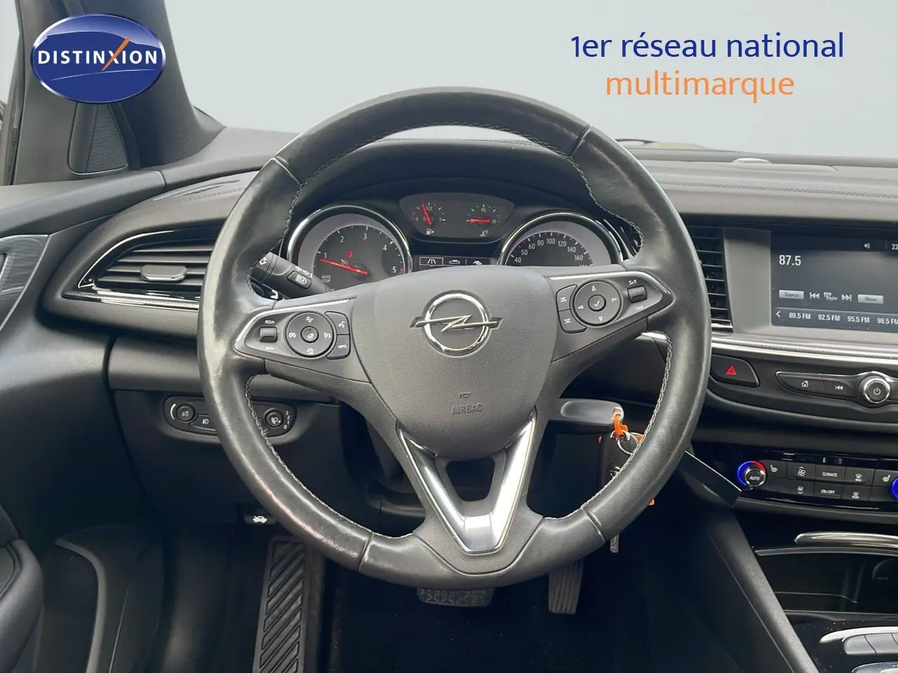 Vue intérieure centrée sur le volant cuir de l'Opel Insignia Sports Tourer 2021, avec tableau de bord et écran multimédia.