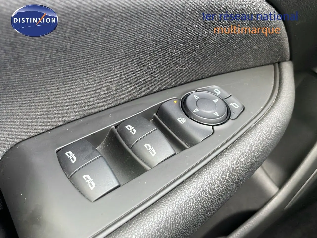 Gros plan sur les commandes de lève-vitres et rétroviseurs côté conducteur de l’Opel Insignia Sports Tourer gris acier.
