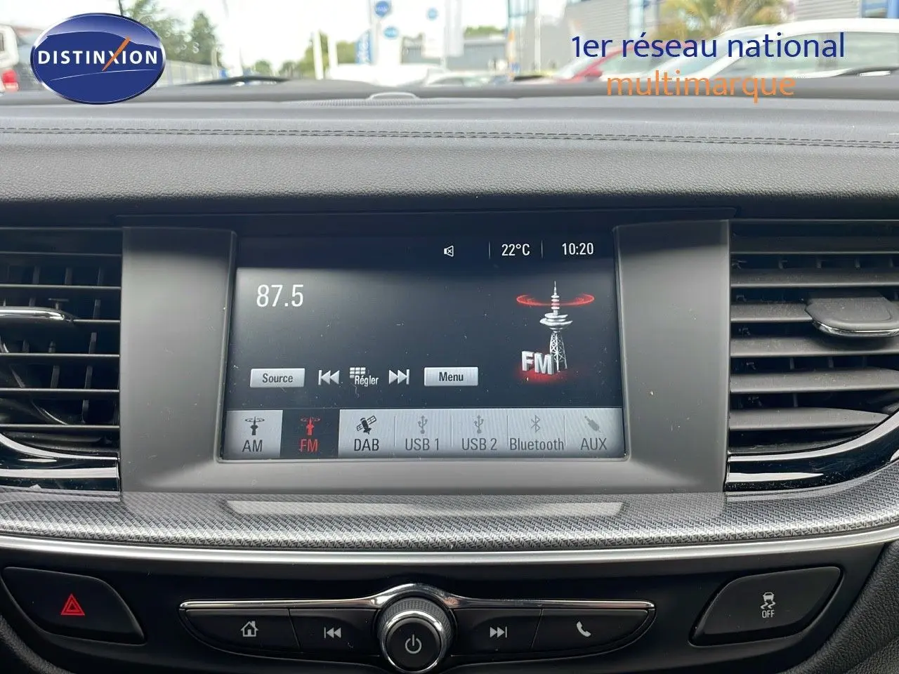 Vue intérieure centrée sur l’écran multimédia de l’Opel Insignia Sports Tourer 2021, affichant la radio FM à 87.5 MHz.