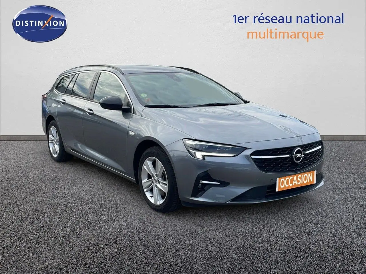 Opel Insignia Sports Tourer gris acier satiné en 3/4 avant droit avec calandre noire et jantes argentées.