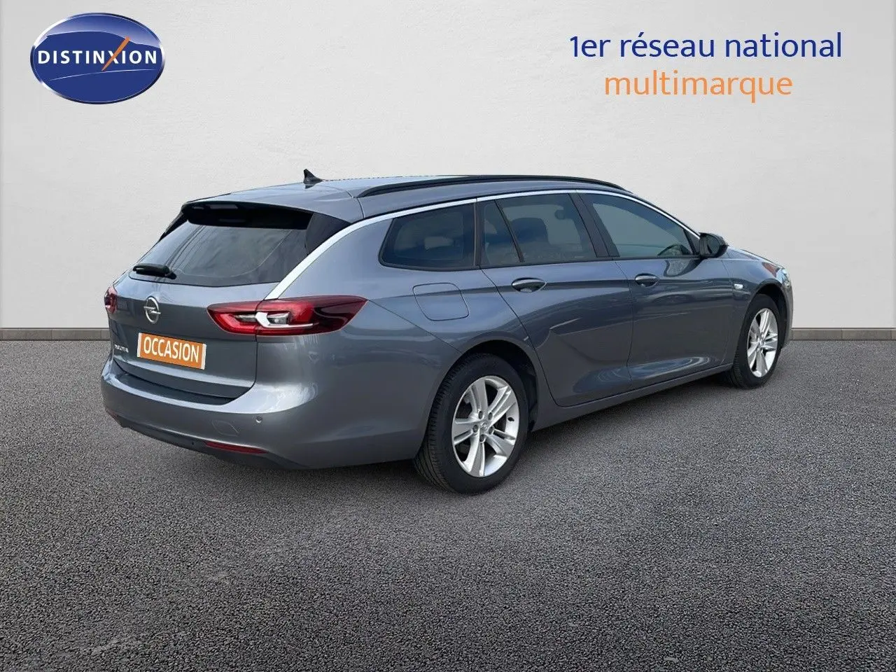 Opel Insignia Sports Tourer gris acier satiné vue 3/4 arrière droit, avec jantes alliage et vitres teintées.