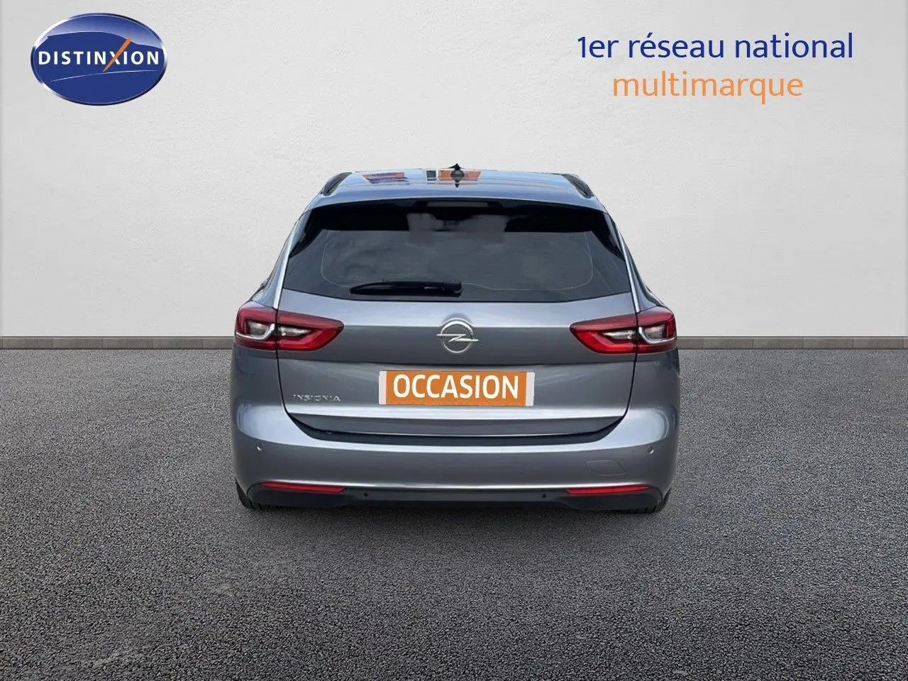 Vue arrière d'une Opel Insignia Sports Tourer gris acier satiné, avec feux arrière LED et plaque "OCCASION".