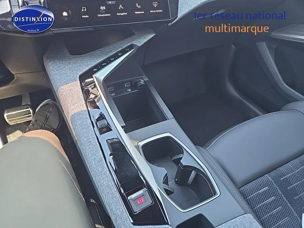 Vue intérieure centrée sur la console centrale et sièges en tissu gris du Peugeot 3008 noir, version hybride 2025.