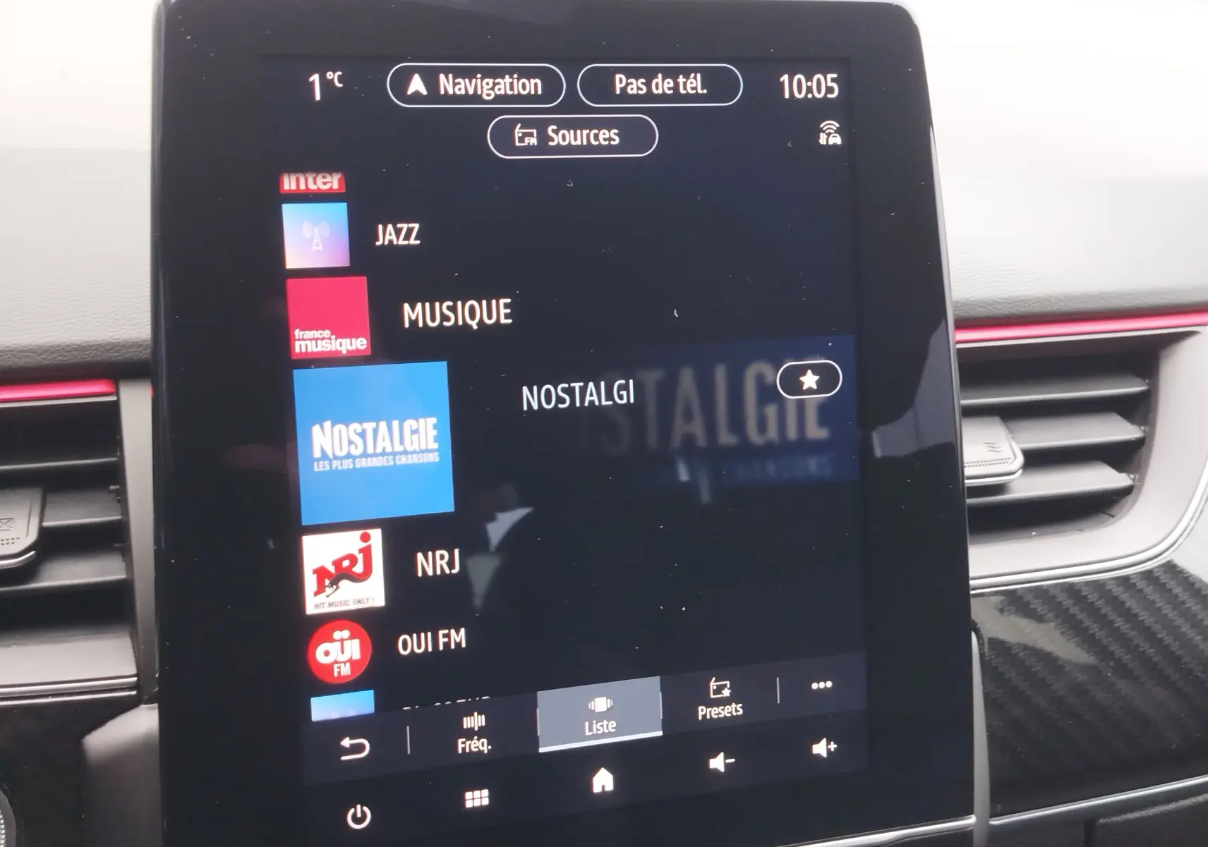 Écran tactile central du tableau de bord du Renault Arkana 1.6 E-Tech, affichant les stations radio avec interface moderne.
