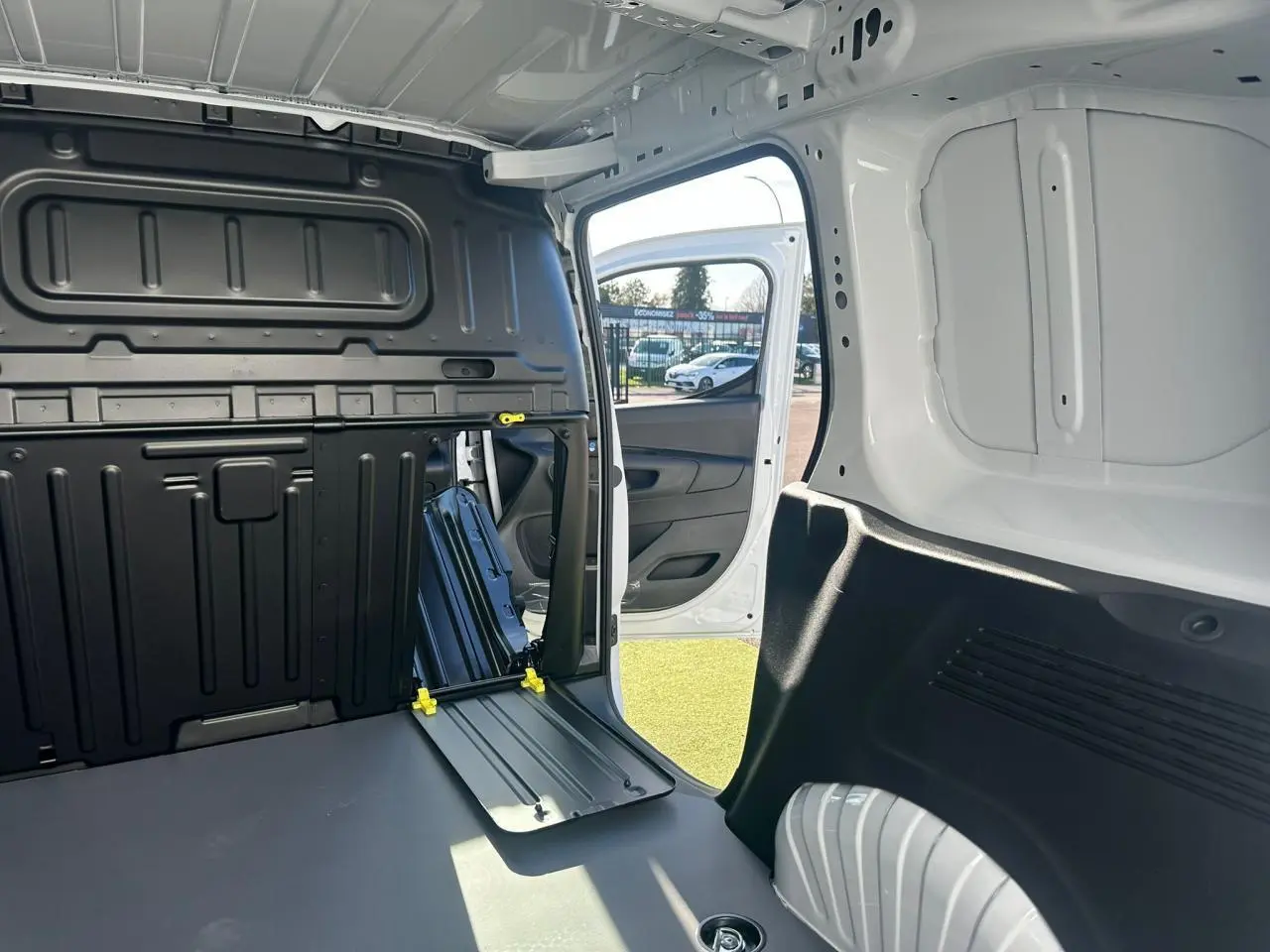 Coffre de rangement ouvert sur le tableau de bord du Citroën Berlingo blanc Icy, vue intérieure frontale.