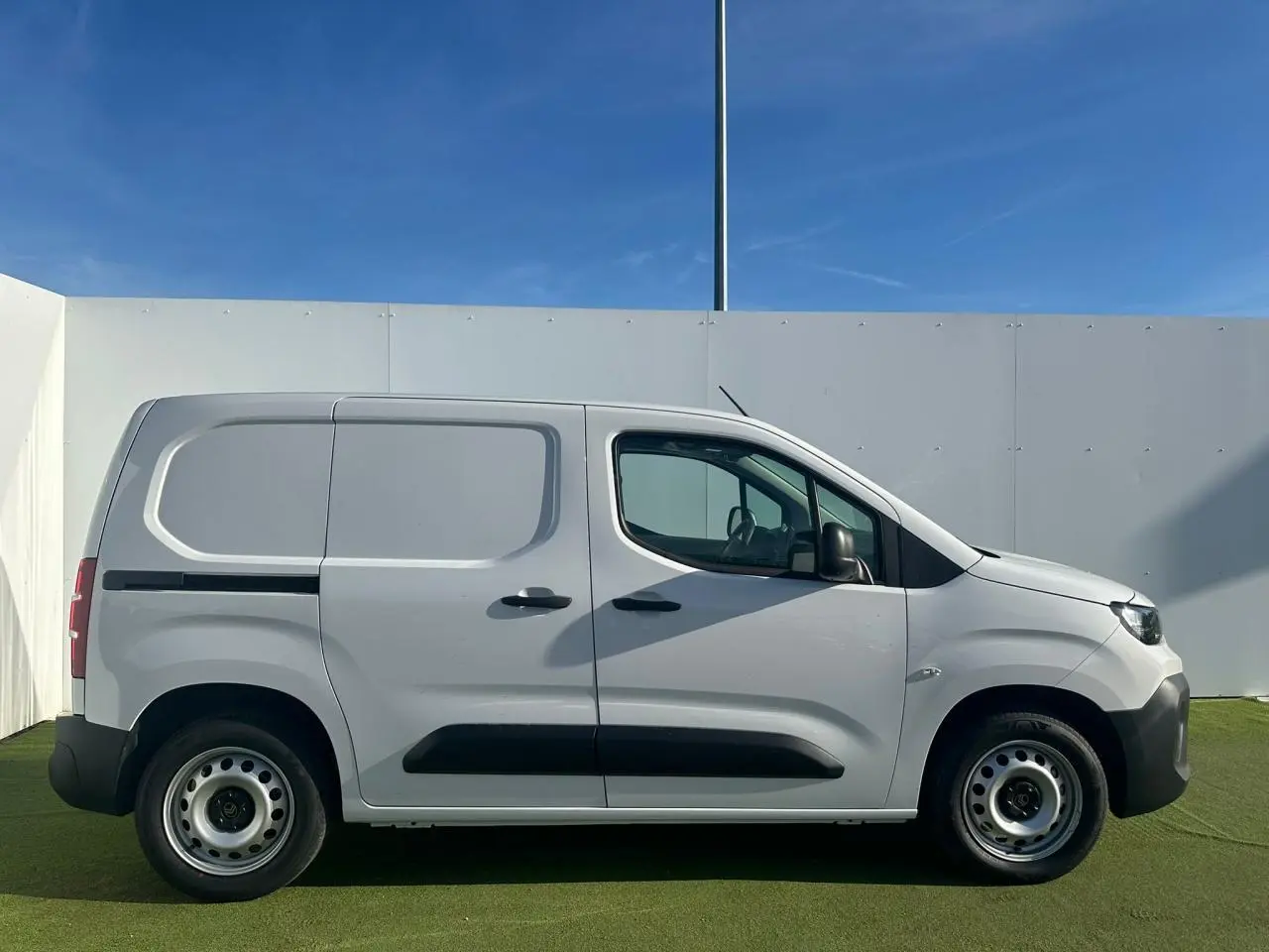 Vue de face du Citroën Berlingo blanc Icy avec pare-chocs noir et calandre distinctive en extérieur.