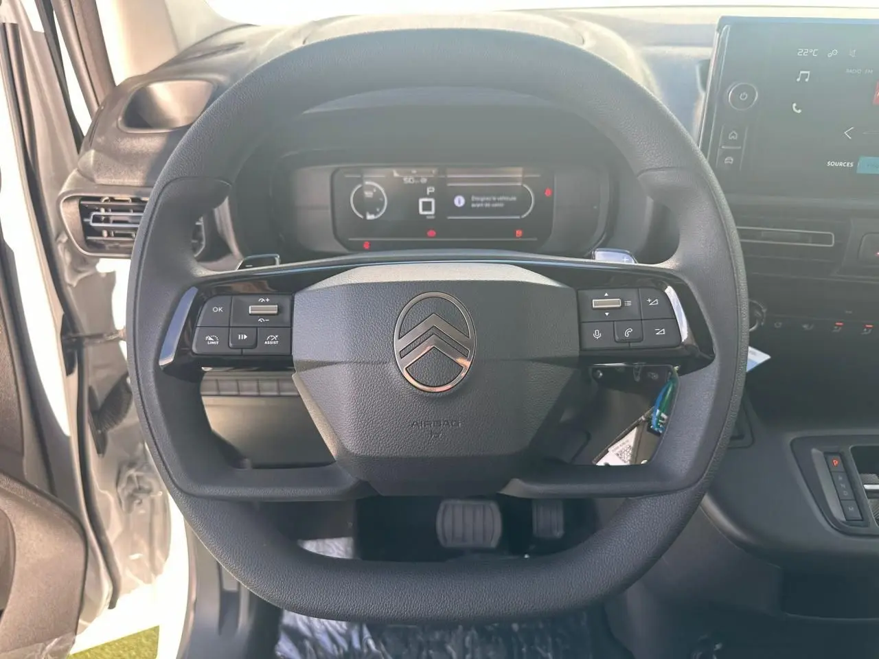 Vue frontale du volant noir du Citroën Berlingo 2026 avec tableau de bord digital et écran tactile à droite.