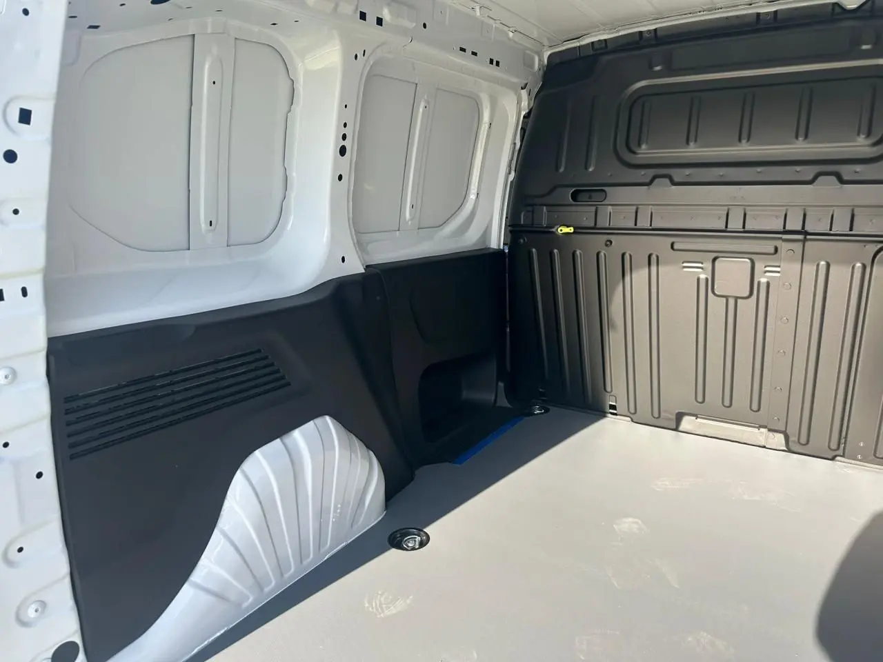 Vue intérieure de la zone de chargement du Citroën Berlingo blanc Icy avec plancher clair et parois noires.