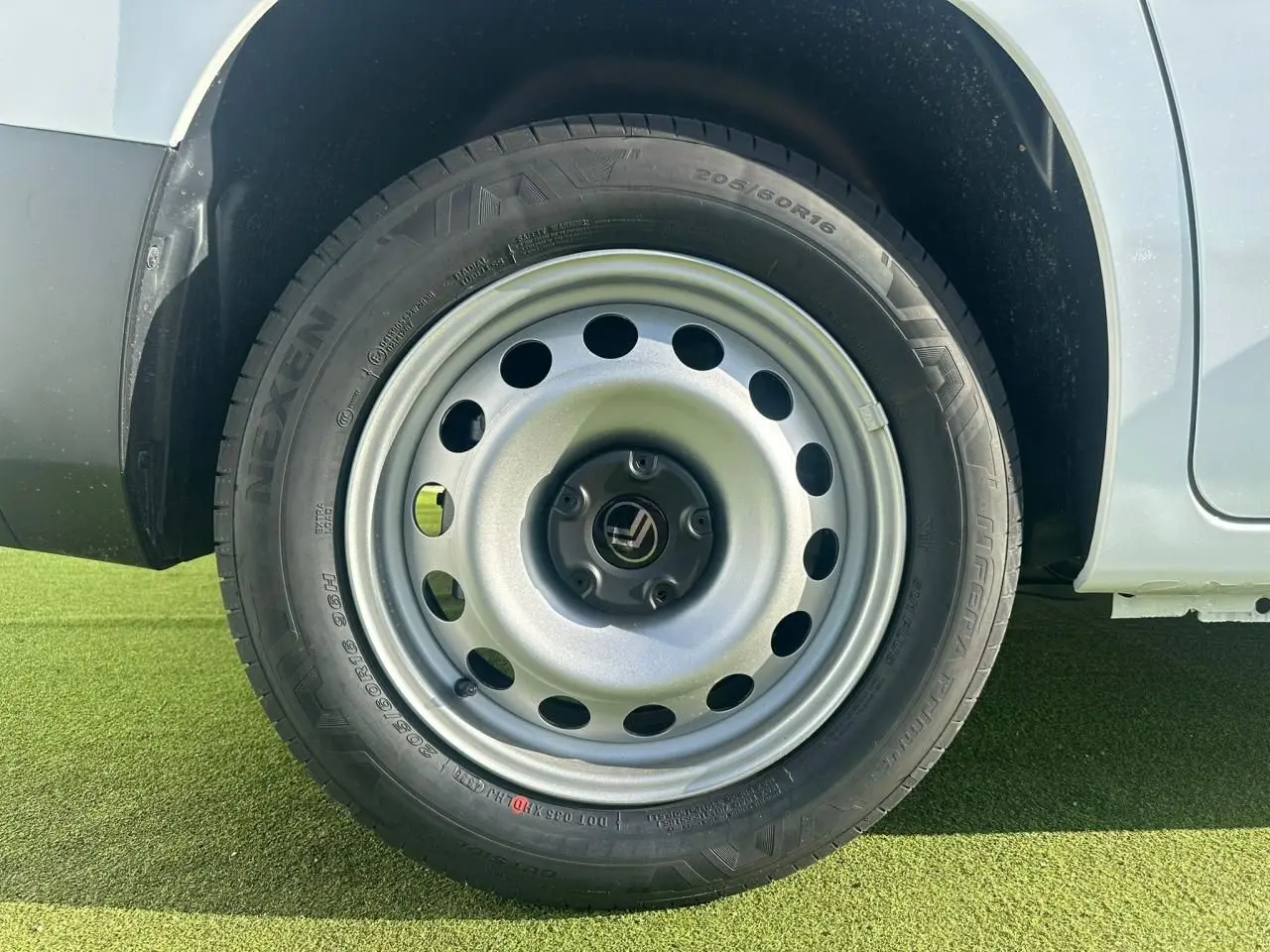 Gros plan sur la roue arrière droite en jante tôle grise du Citroën Berlingo blanc Icy 2026.