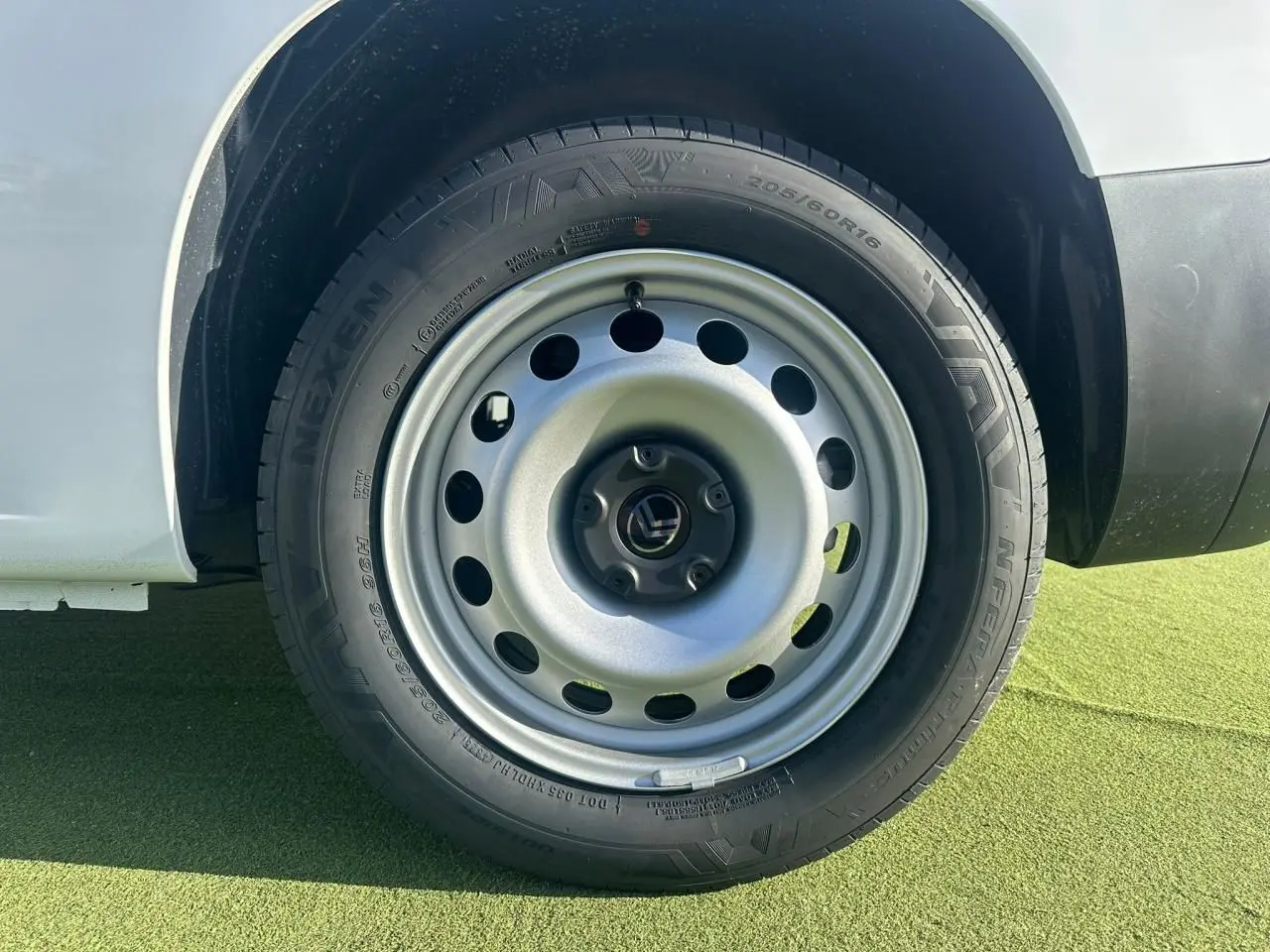 Gros plan sur la roue tôle 16 pouces grise du Citroën Berlingo blanc Icy, côté arrière droit du véhicule.