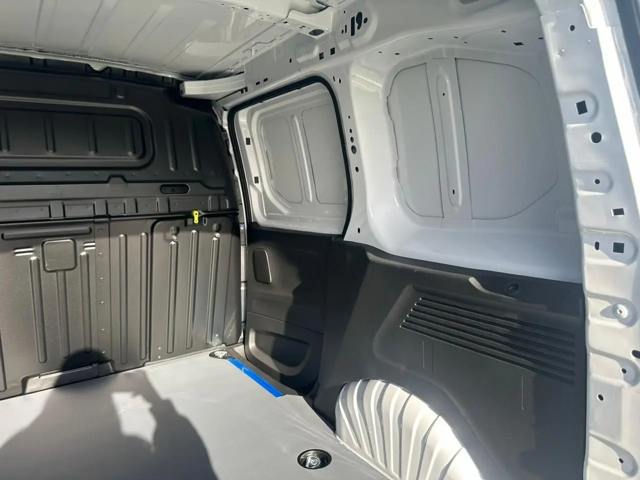 Intérieur arrière du Citroën Berlingo blanc Icy, vue côté droit montrant la zone de chargement et parois tôlées.