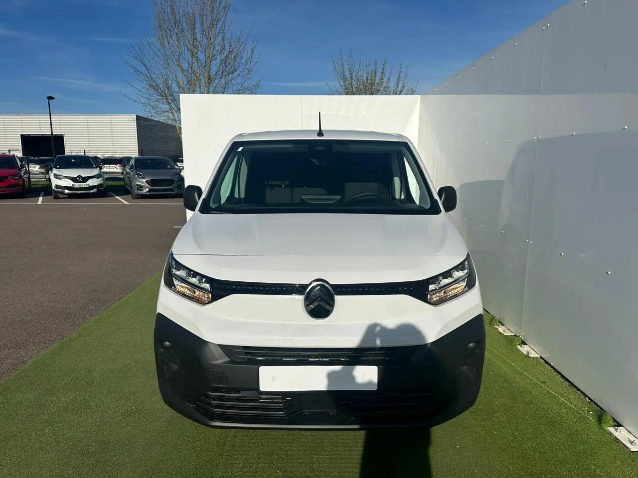 Vue 3/4 arrière droite du Citroën Berlingo blanc Icy version utilitaire avec portes arrière battantes et jantes tôles grises.