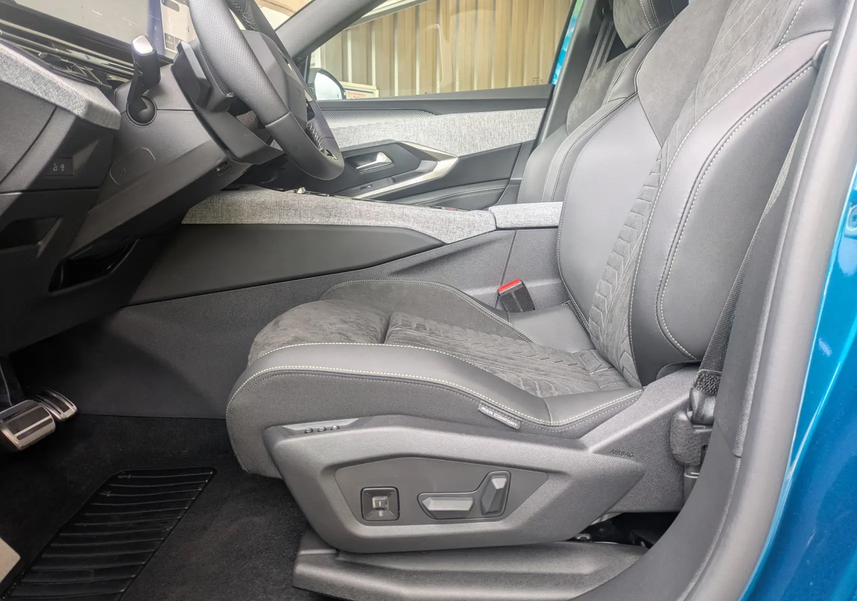 Vue intérieure côté conducteur du Peugeot 3008 Hybrid 2026, siège Alcantara noir avec réglages électriques et volant partiel.