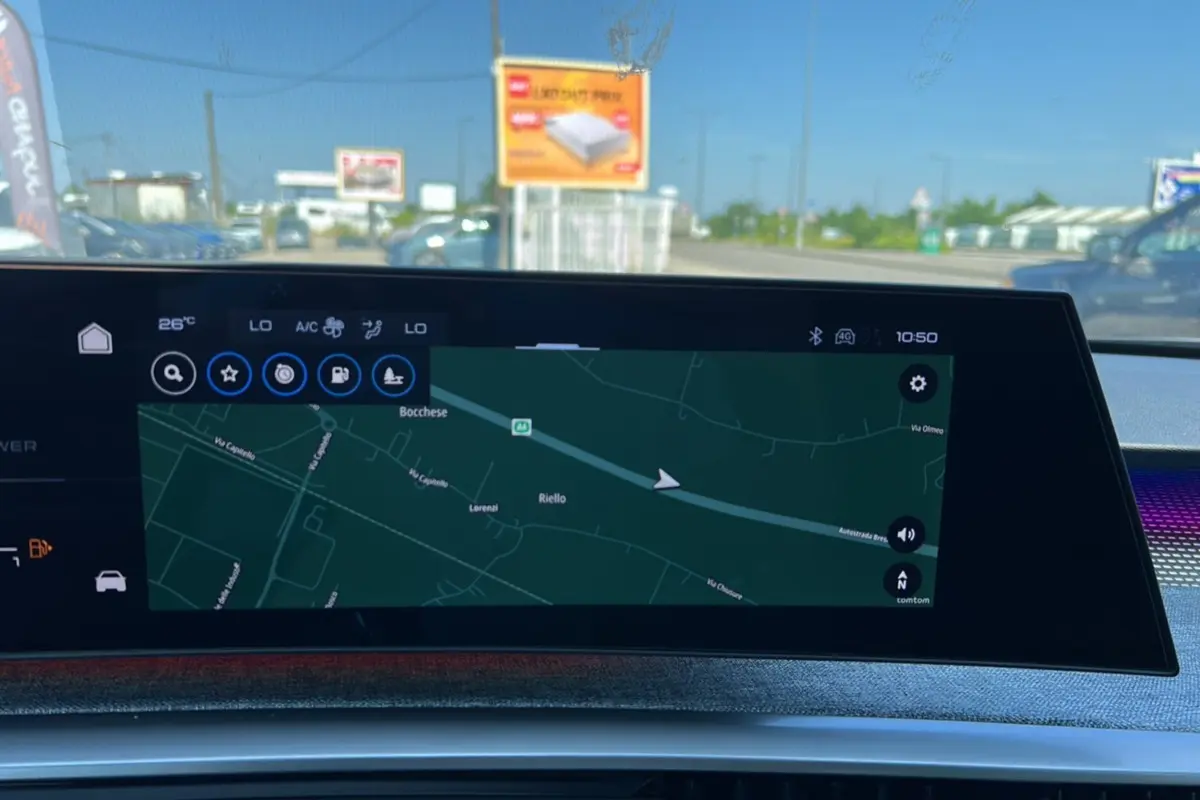 Écran central du tableau de bord du Peugeot 3008 Hybrid 145 GT, affichant la navigation GPS en extérieur lumineux.