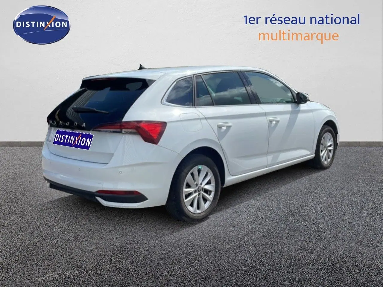 Vue 3/4 arrière droite d'une Skoda Scala blanche Glacier avec vitres teintées et jantes alliage 16 pouces.