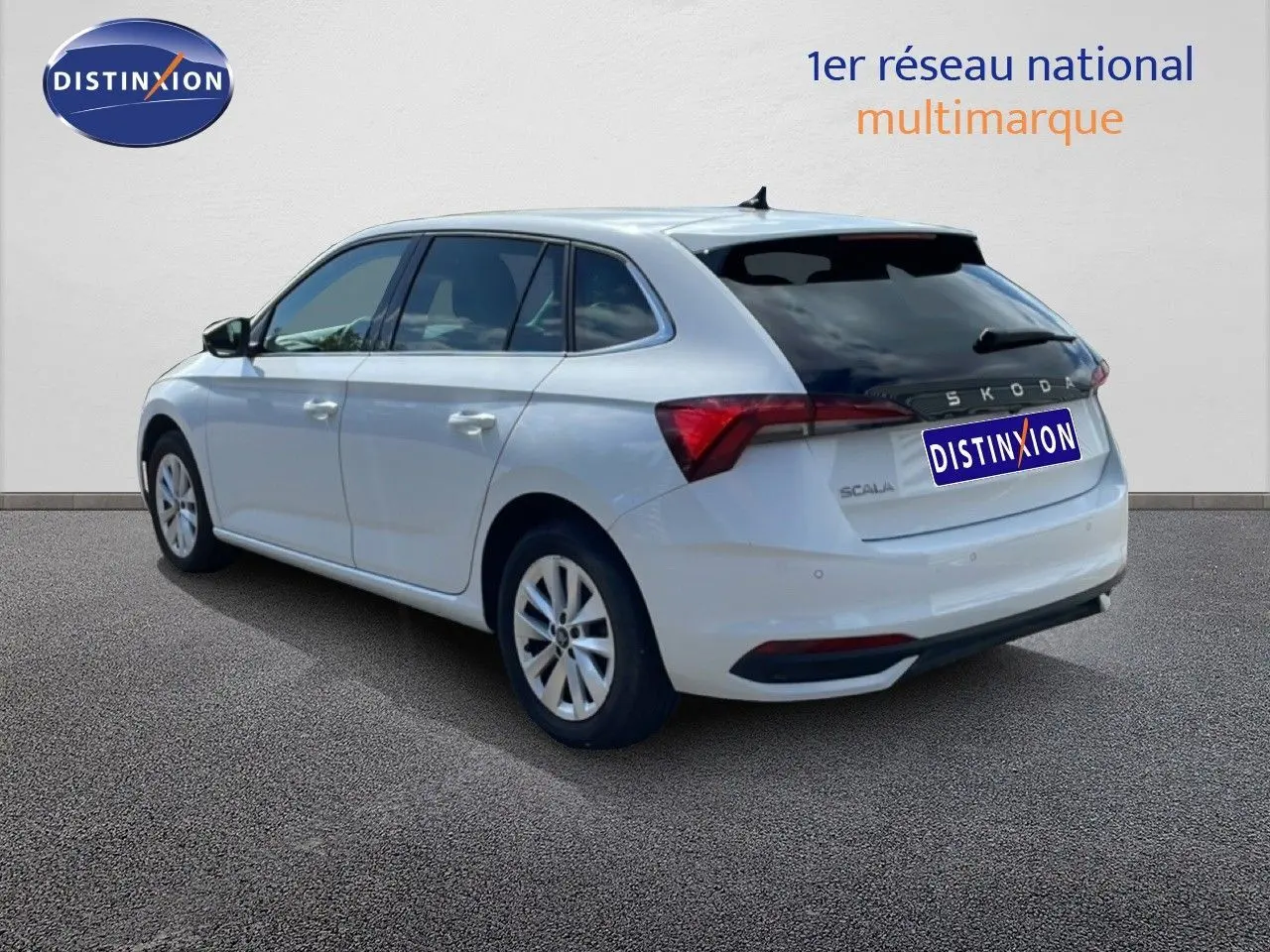 Vue 3/4 arrière droite d'une Skoda Scala blanche Glacier avec vitres teintées et jantes alliage 16 pouces.