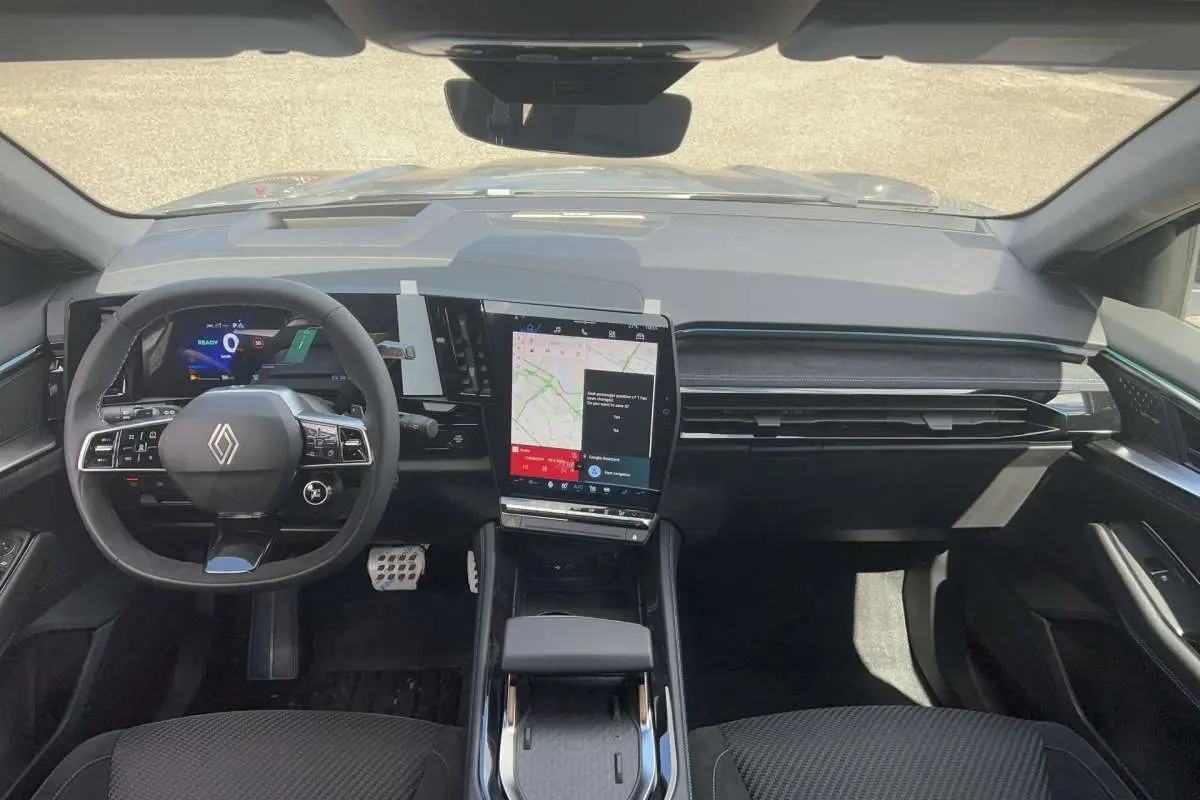 Vue intérieure frontale du tableau de bord du Renault Austral gris schiste, avec écran tactile vertical et volant multifonctions cuir.