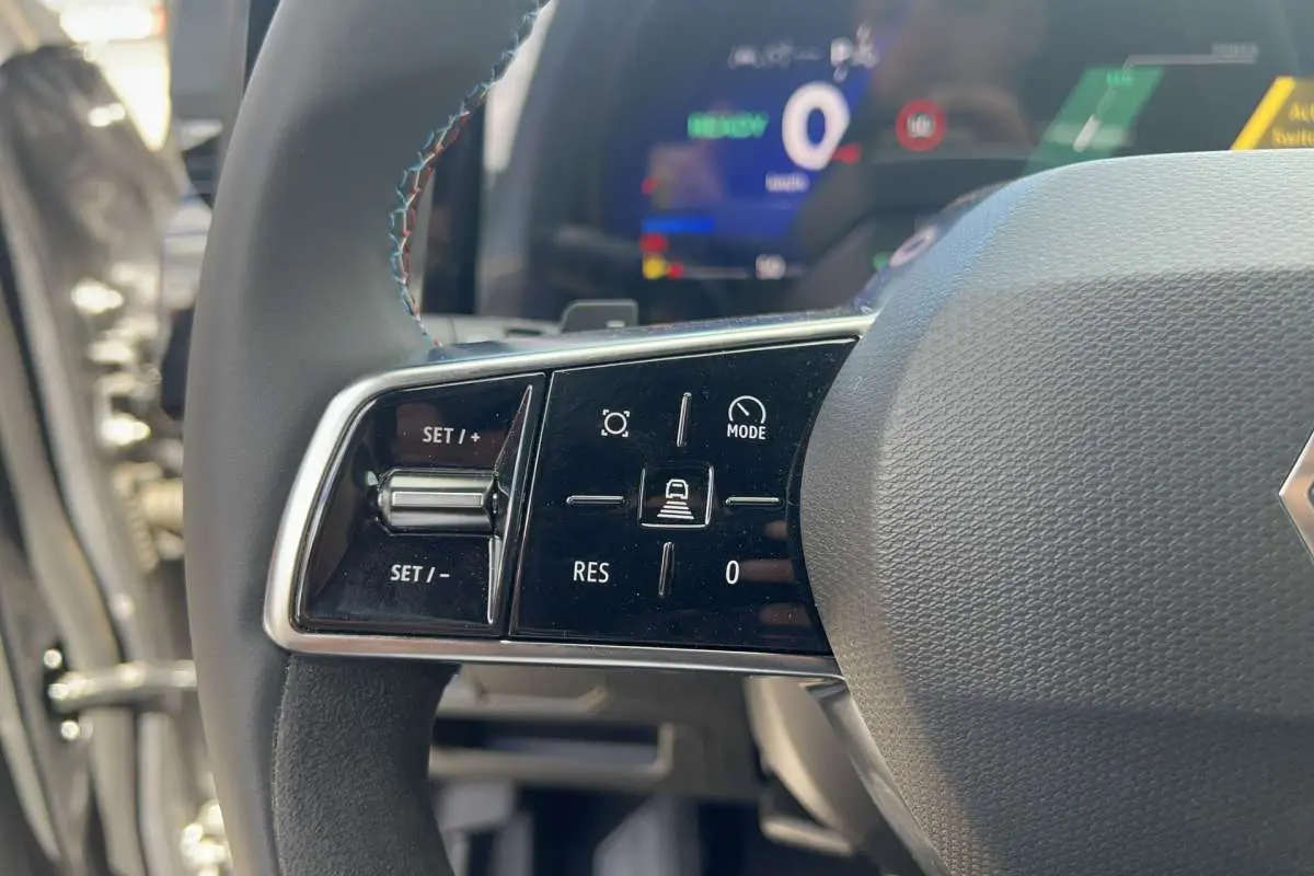 Gros plan sur la partie gauche du volant cuir multifonctions du Renault Austral 200 Esprit Alpine, avec commandes de régulateur.