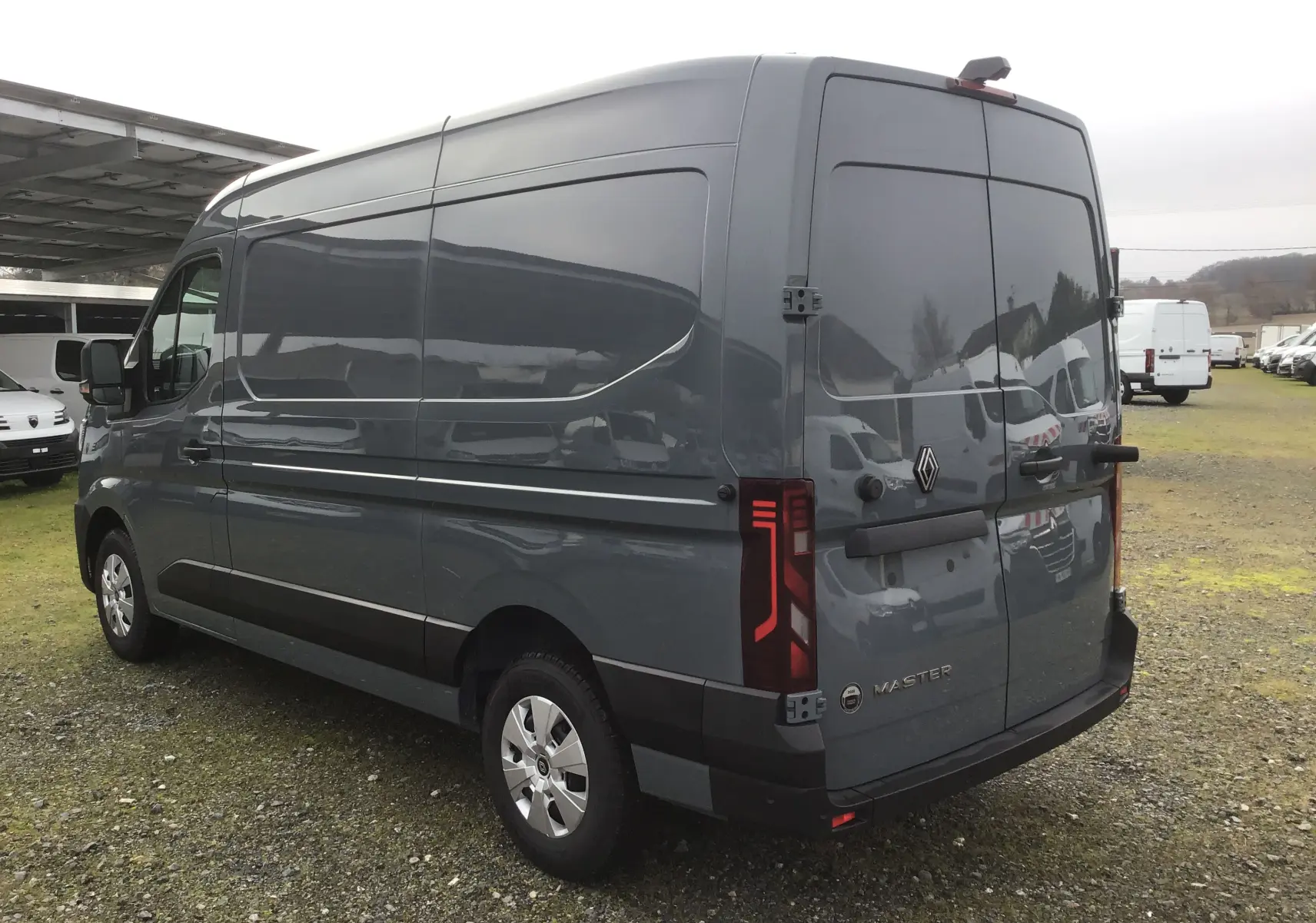 Vue 3/4 arrière droite d’un Renault Master gris urbain, fourgon utilitaire avec feux arrière LED et jantes acier.