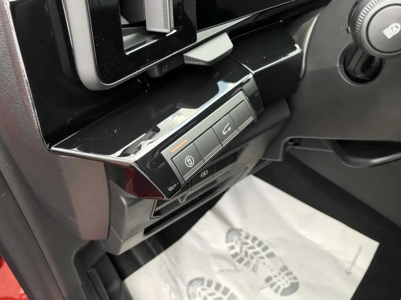 Détail des commandes sous le tableau de bord côté gauche du Renault Austral rouge noir full hybrid 2025.