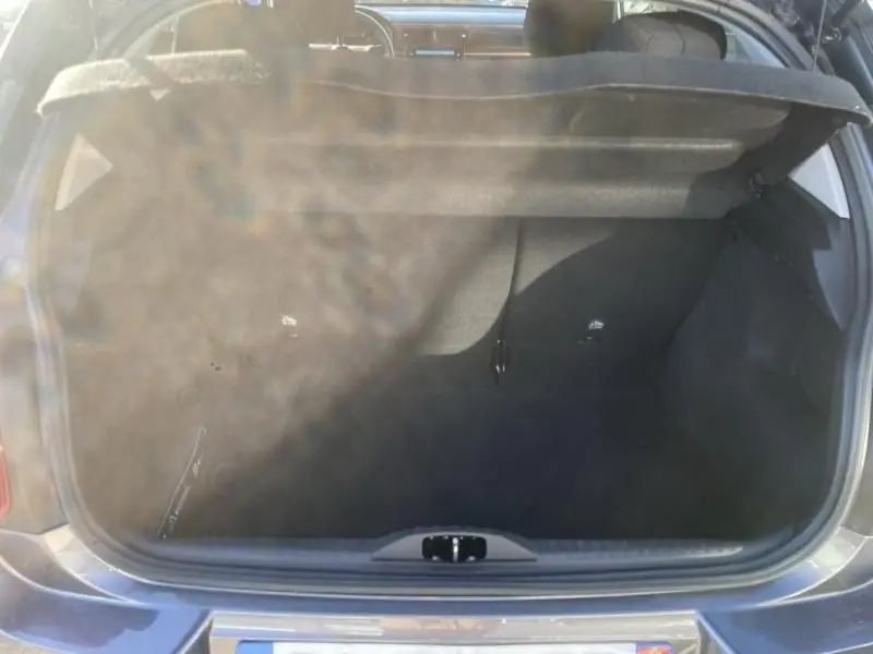 Coffre ouvert vu de l'arrière d'une Citroën C3 gris foncé 2021, montrant l'espace de chargement vide et la tablette arrière.