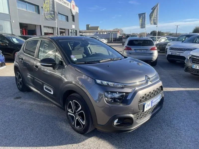 Citroën C3 1.2 PureTech 83 CV Feel Pack gris foncé vue 3/4 avant droit sur parking ensoleillé.