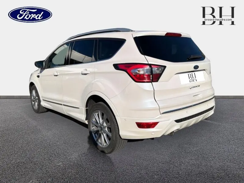 Vue 3/4 arrière droite d'un Ford Kuga blanc Premium Platinum avec vitres teintées et jantes alu.