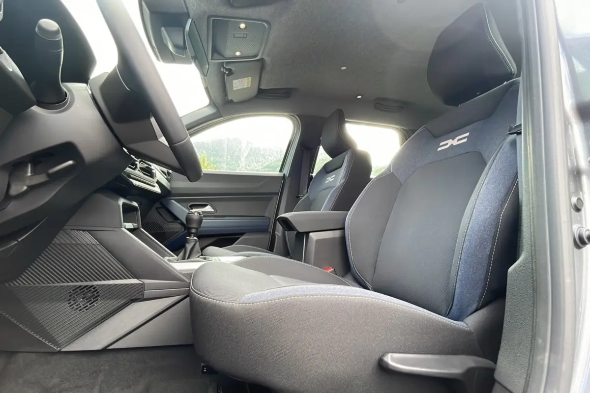 Vue intérieure côté droit du Dacia Bigster gris schiste, mettant en valeur les sièges avant avec logo DC brodé.