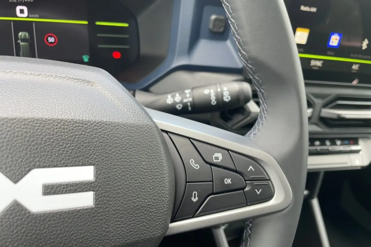 Gros plan sur le volant cuir et les commandes multifonctions du tableau de bord du Dacia Bigster 2025.