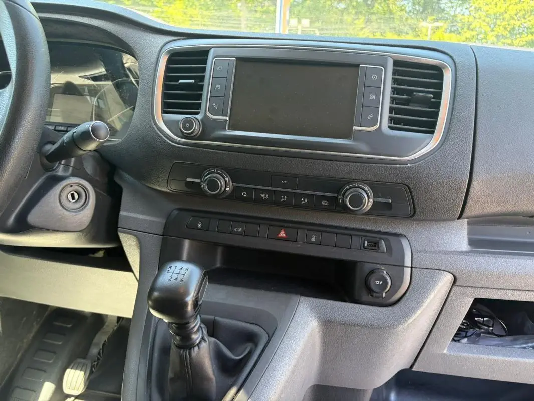 Vue rapprochée de l’intérieur du Peugeot Expert Fourgon blanc 2019, montrant la console centrale avec boîte manuelle et écran tactile.