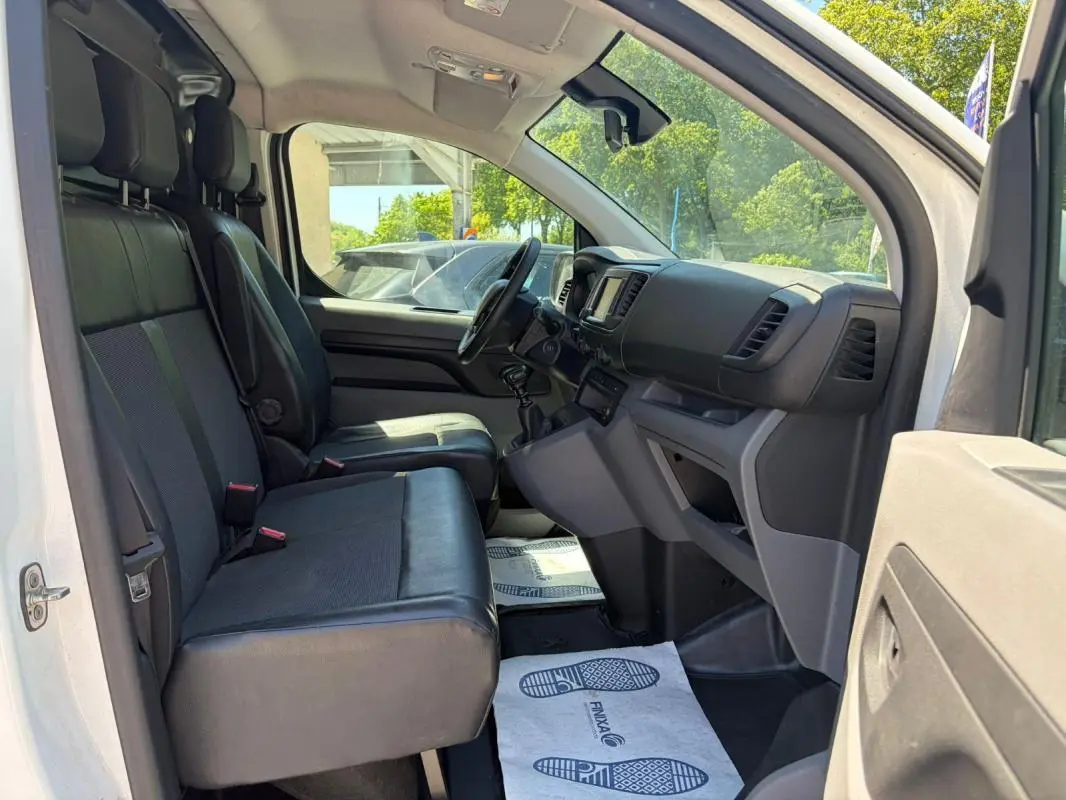 Intérieur avant droit du Peugeot Expert Fourgon blanc 2019, montrant sièges en cuir, tableau de bord et volant multifonctions.