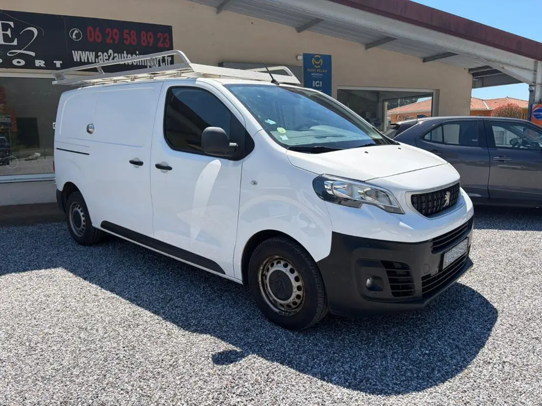 Peugeot Expert Fourgon blanc en 3/4 avant droit avec galerie de toit et pare-chocs noirs visibles.