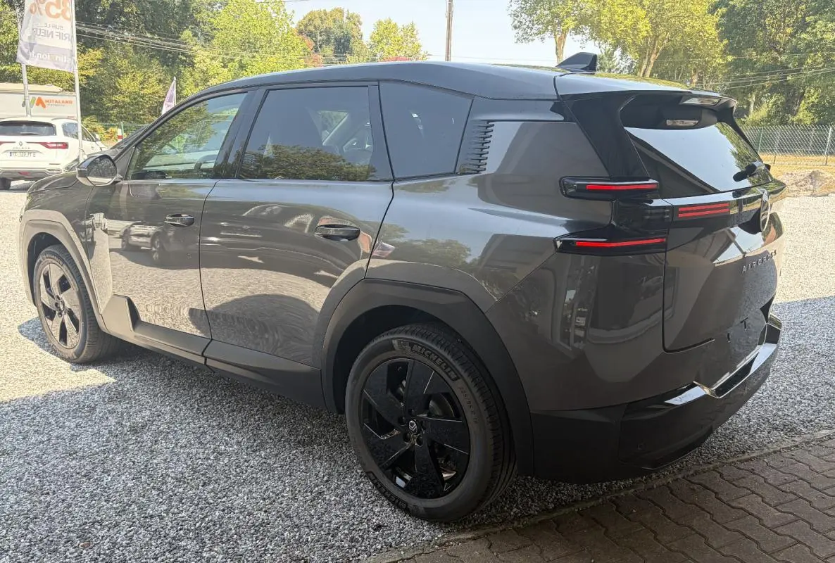Vue 3/4 arrière gauche d’un Citroën C5 Aircross gris avec jantes noires et feux arrière horizontaux LED.