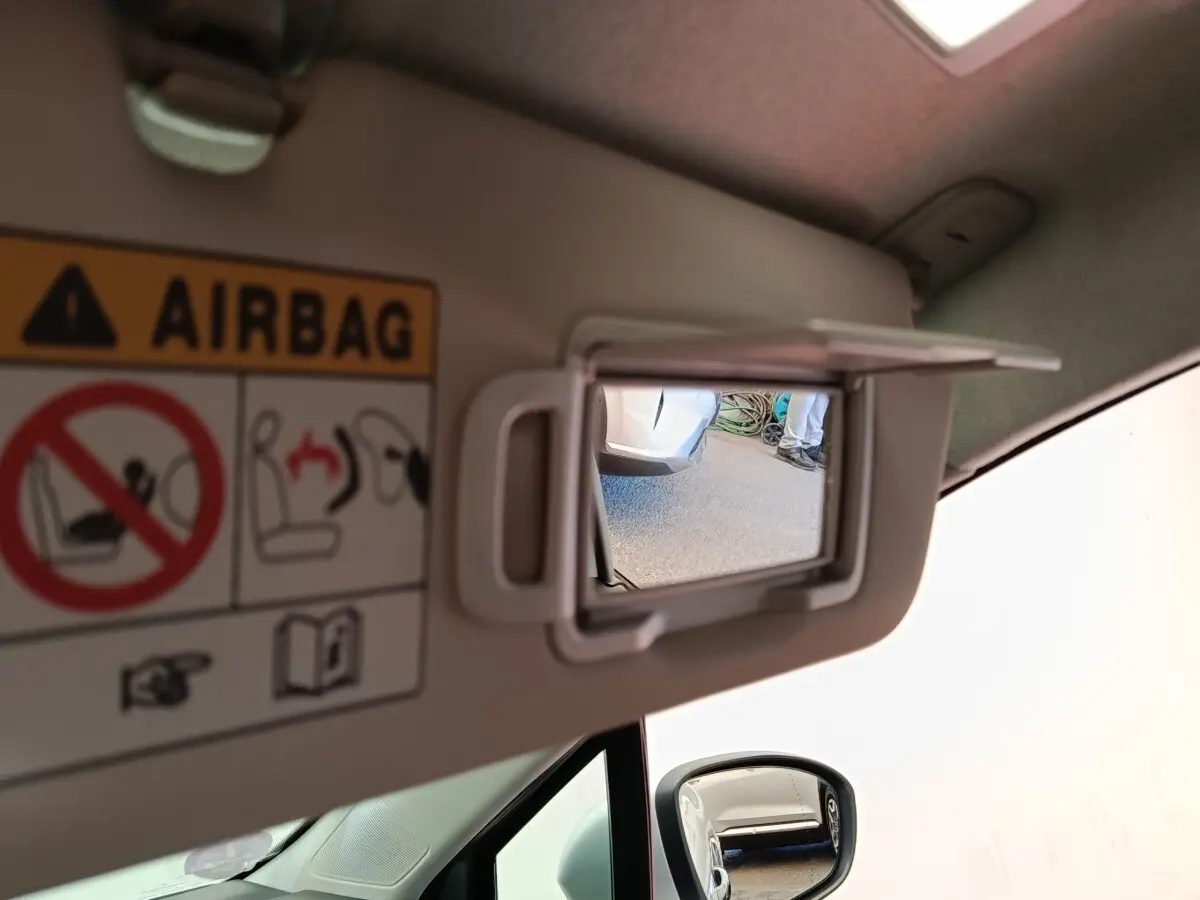 Miroir de courtoisie ouvert sur pare-soleil côté conducteur d’une Renault Clio Business gris clair, intérieur beige.